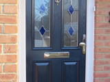 Coloured wood effect uPVC exterior door with diamond colour leaded glass style
